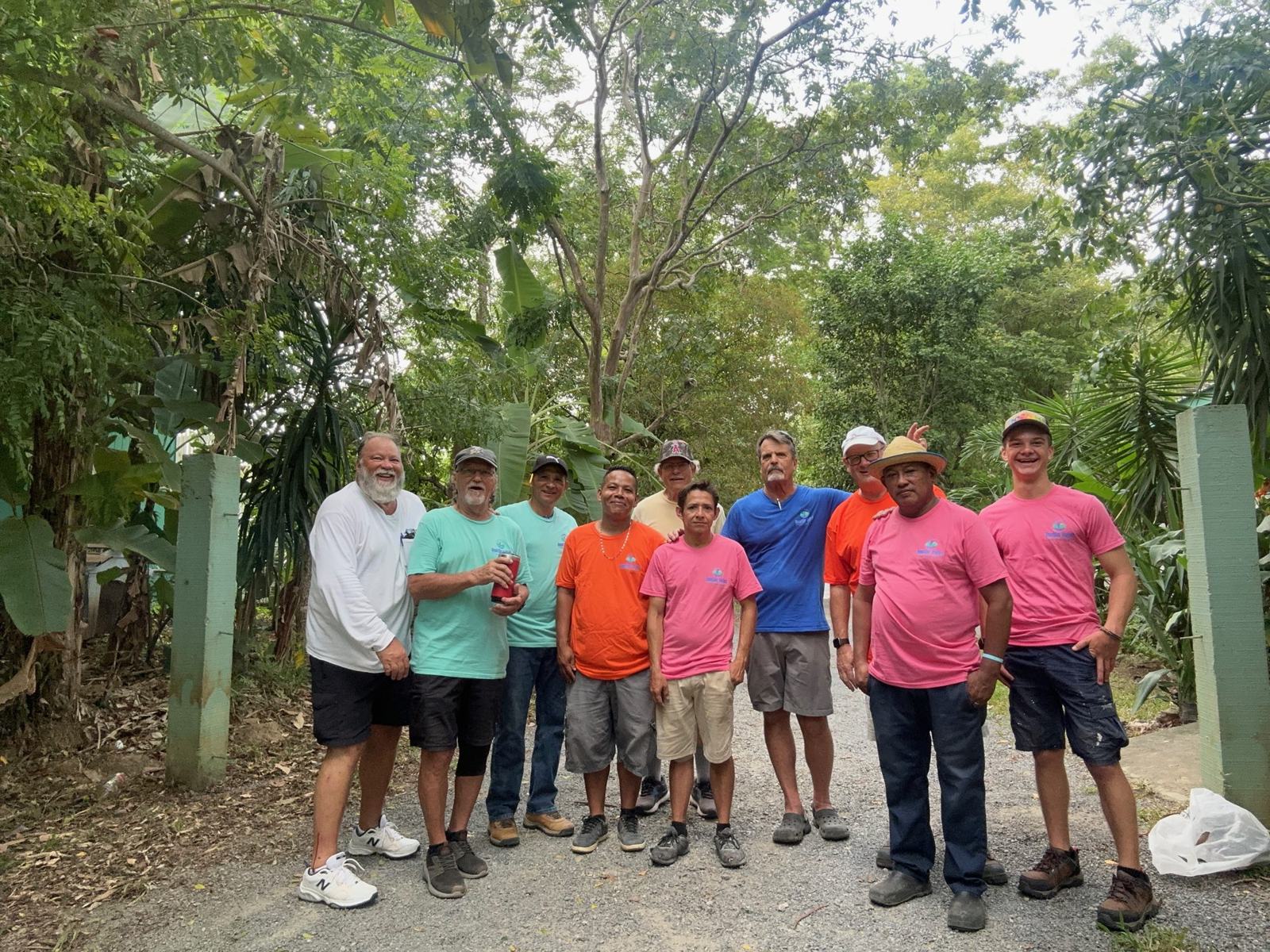 The volunteer team in matching work shirts gathered outside the VoTec office