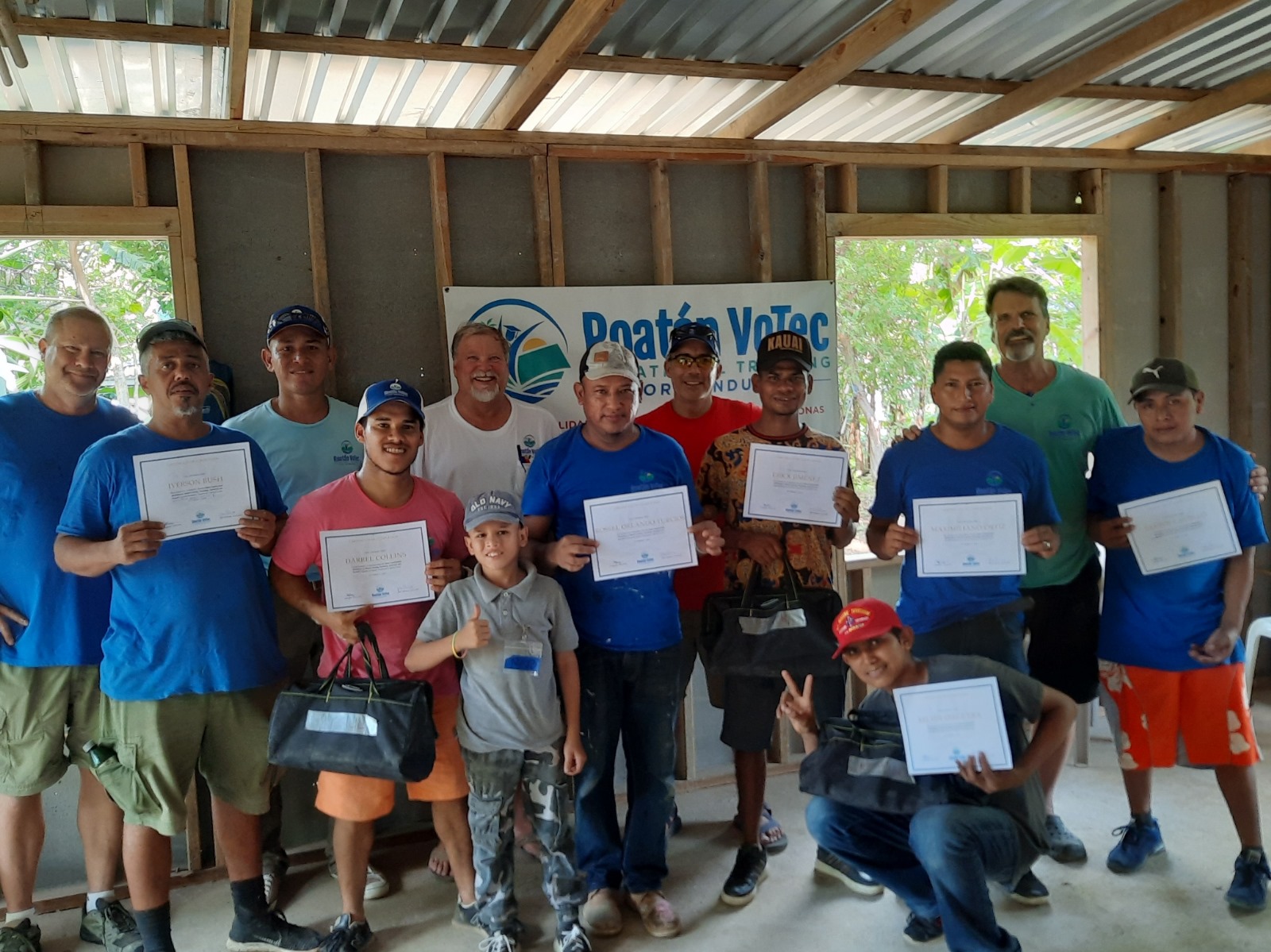 RVT graduates proudly holding certificates at graduation ceremony in Roatan Honduras