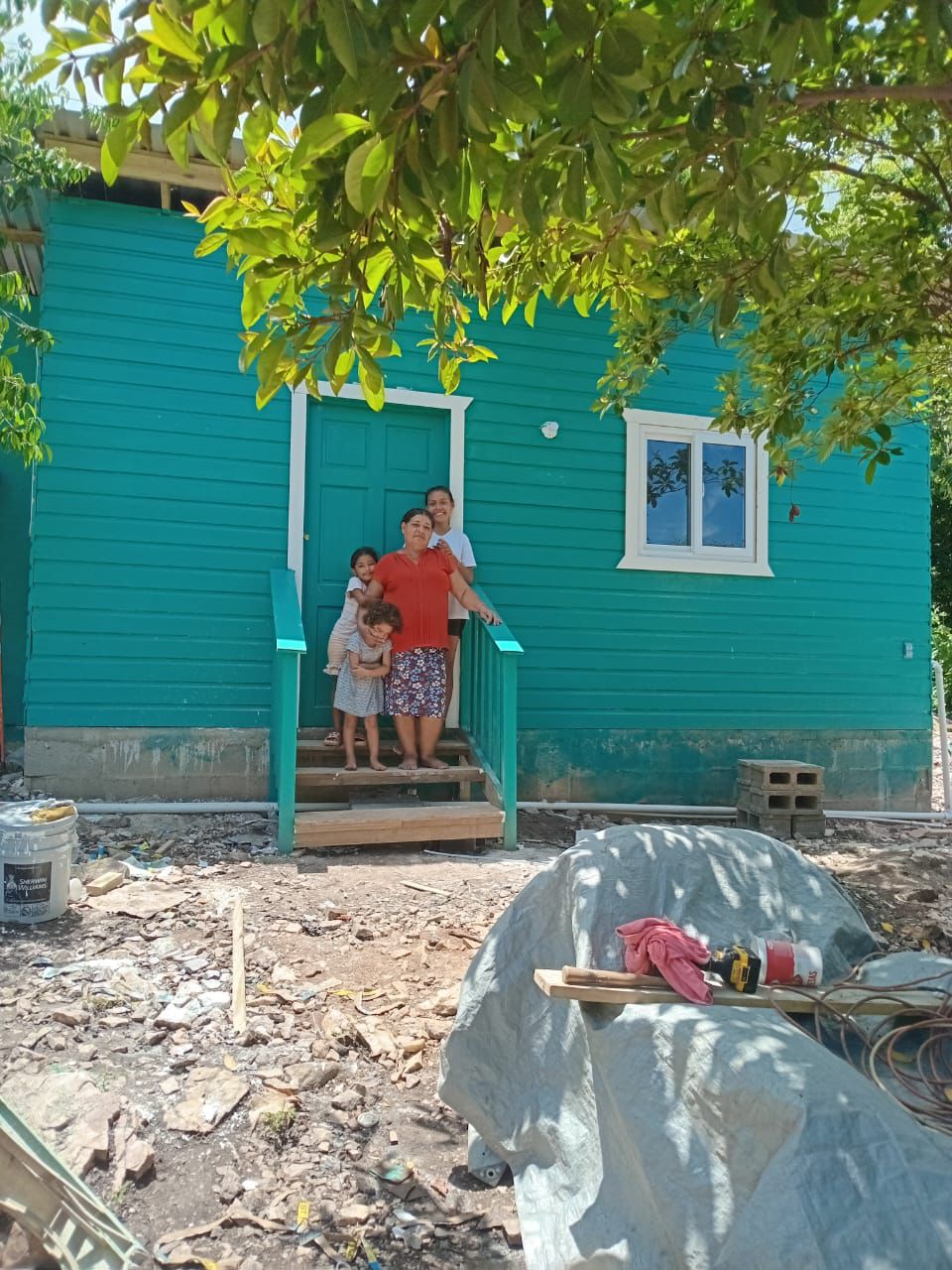 A family at the door of the house RVT students built